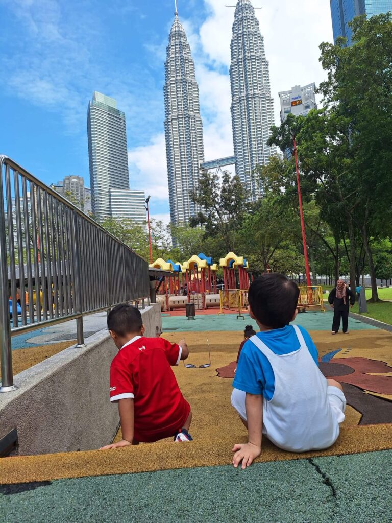 two boys sitting by the stairs at the KLCC park playground