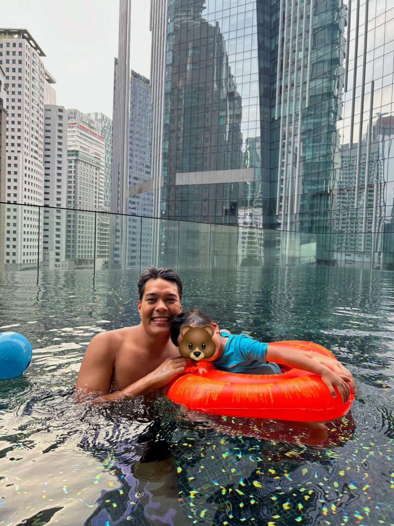 father and son swimming in the RuMa hotel swimming pool 