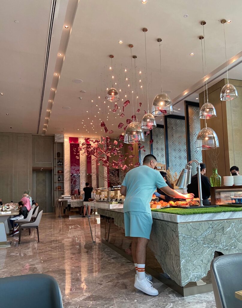 man getting food at the breakfast buffet at Four Seasons Kuala Lumpur Hotel 