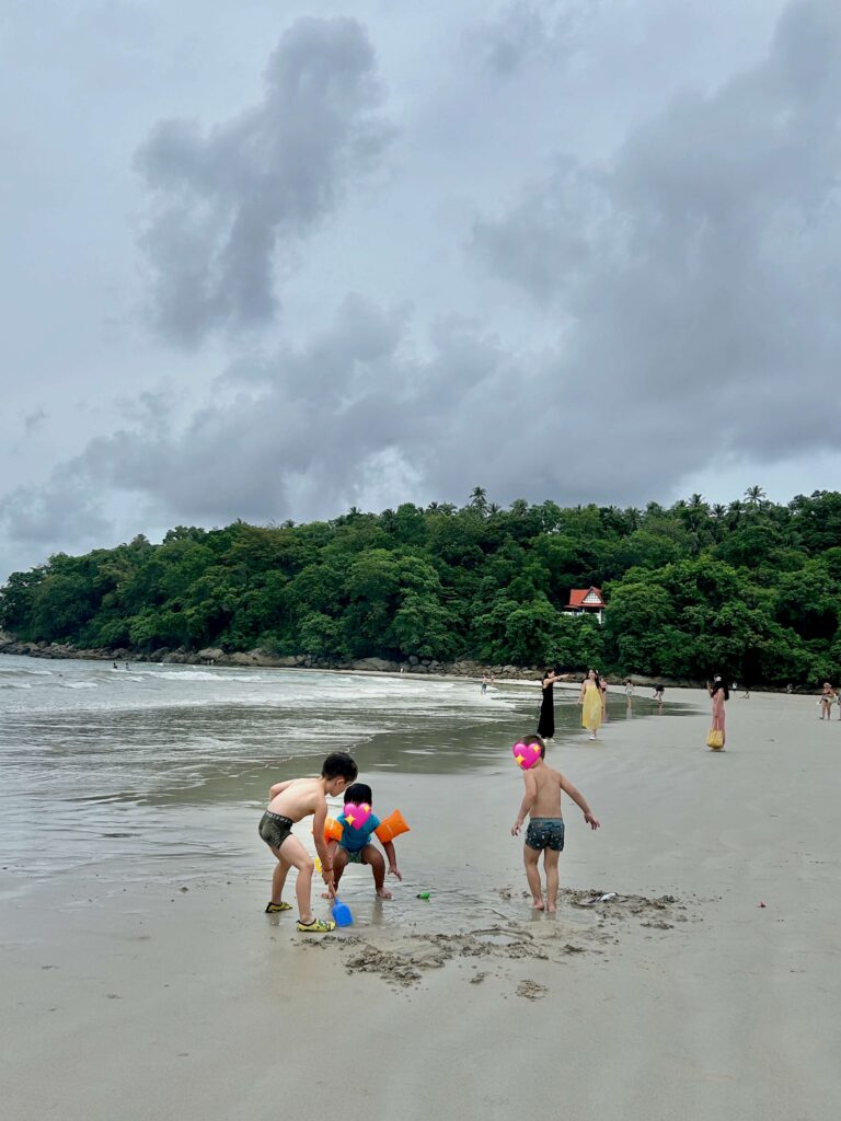 Three boys having fun playing with sun at the Kata Beach in Phuket 