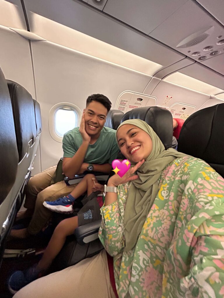 A family of mom, dad, and their son sitting in a row in an airplane 