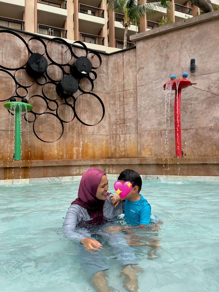 Woman sitting and smiling at her son in the kids pool at Novotel Phuket Kata Avista