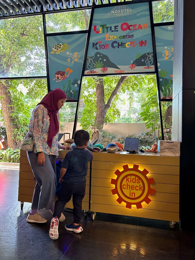 A mom with her son at the Kids Check In Counter at the Novotel Phuket Kata Avista Hotel 